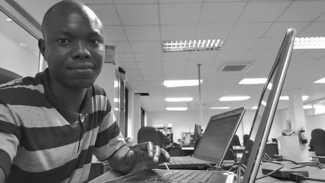 AI-Exposed Jobs Show Faster Advertised Pay Gains, With Seniority Changing the Picture A software developer sits at a laptop in an office with rows of desks and computers behind him