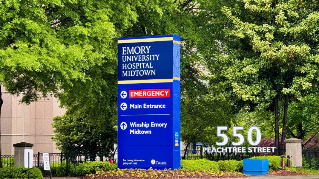 Atlanta Healthcare Hiring Event Scheduled for September 30 Has Ended; Registration Closed at 11 a.m. A tall blue Emory University Hospital Midtown sign with emergency and main entrance directions beside a 550 Peachtree Street marker and trees