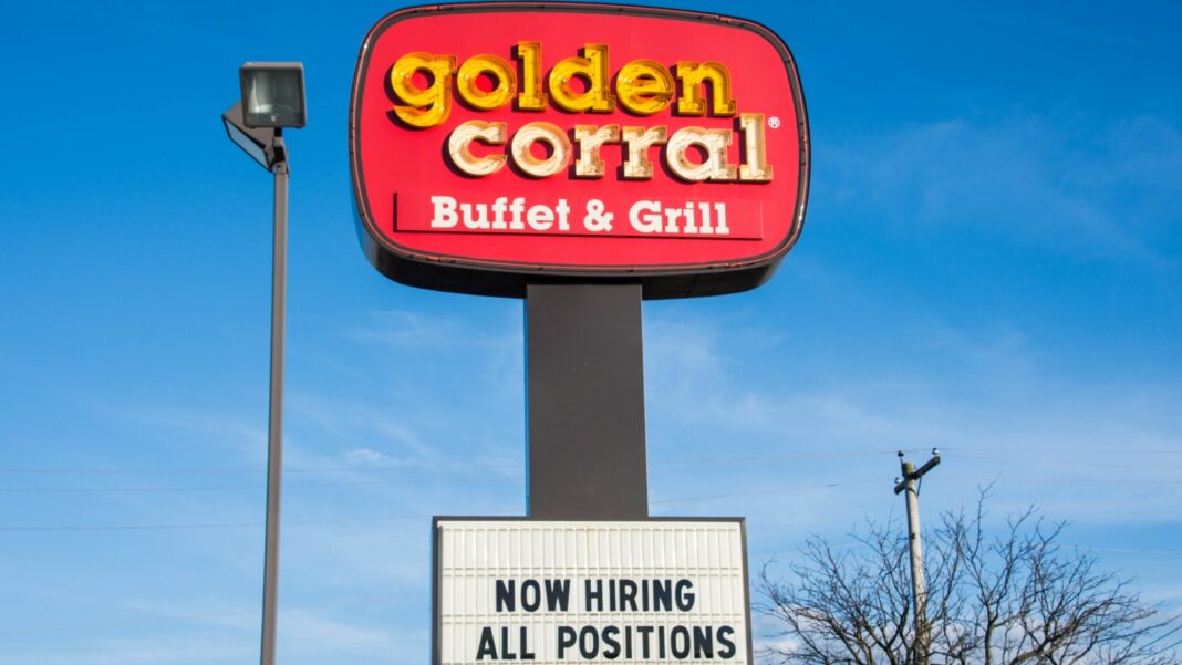 A Golden Corral restaurant sign with a marquee below reading Now Hiring All Positions