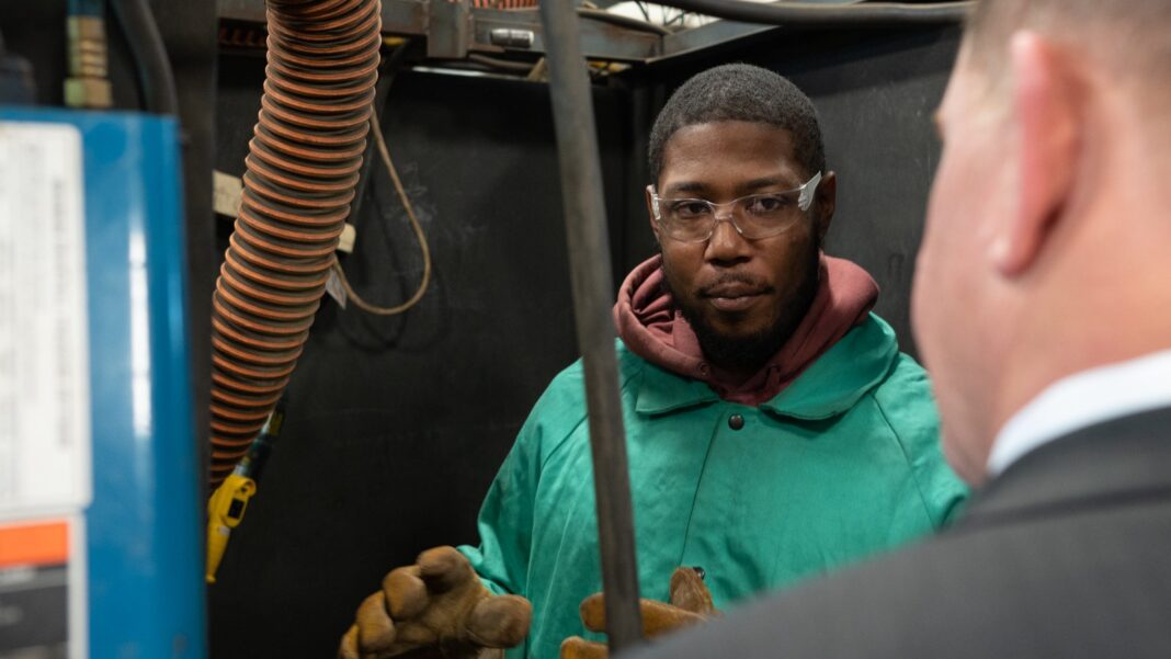 McKinsey Model Says 11 Million U.S. Workers May Need to Switch Occupations by 2035 A trainee in a green welding jacket and safety glasses stands in a welding booth talking with a man in a suit