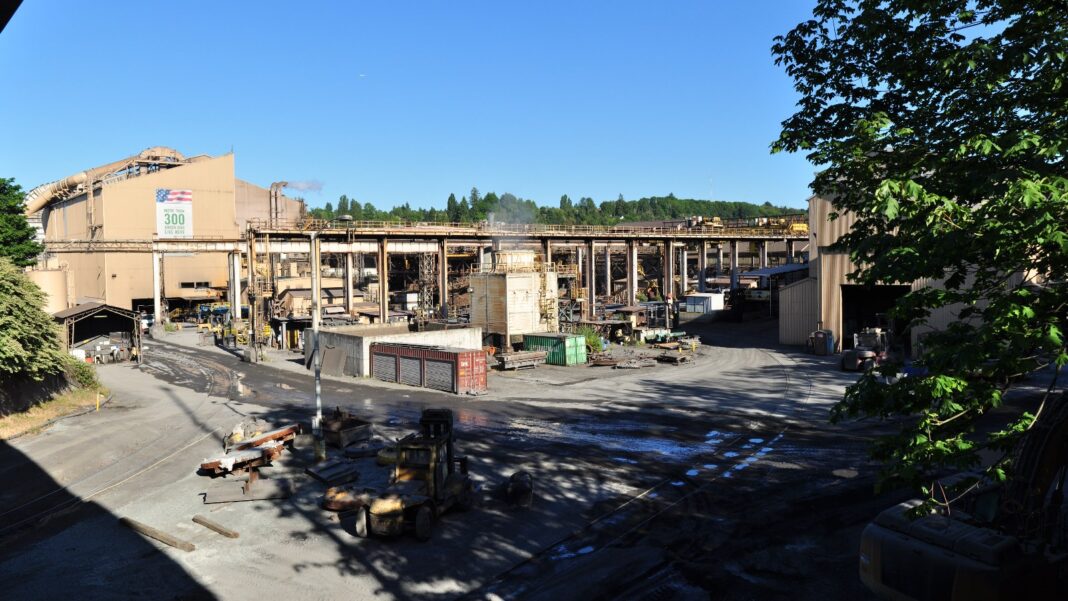 Mesabi Metallics Plans $15 Billion Iowa Steel Mill With 1,750 Permanent Jobs Panoramic view of a steel mill yard with large industrial buildings, ductwork and scrap piles under a clear sky