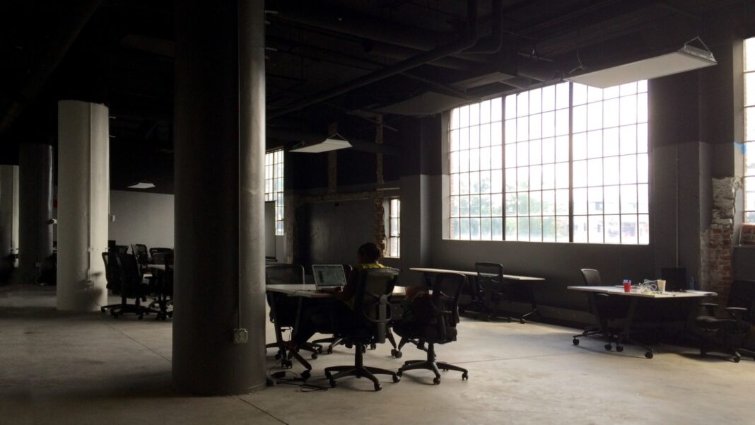 More Than Half of Surveyed Workers Would Trade Pay for Greater Job Security A single person works at a desk in a large, dim, mostly empty open-plan office