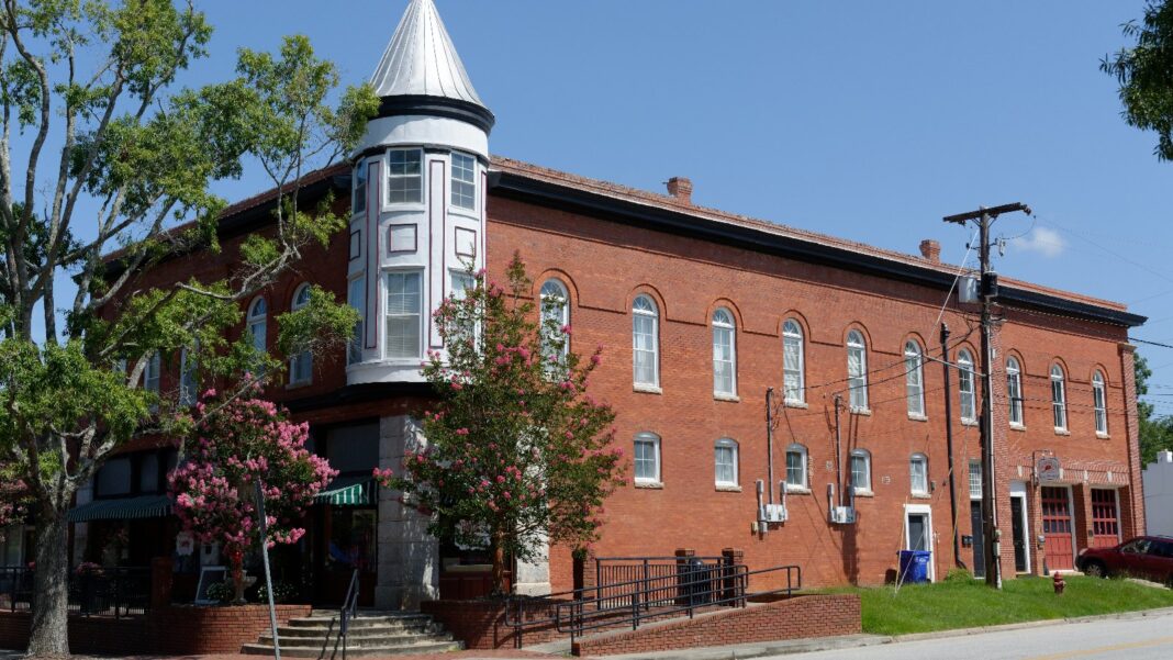 Nine Georgia Industrial Sites Gain Recent Readiness Certifications, but Jobs Depend on Future Projects A three-story red-brick commercial building with a corner turret and street trees in downtown Louisville, Georgia