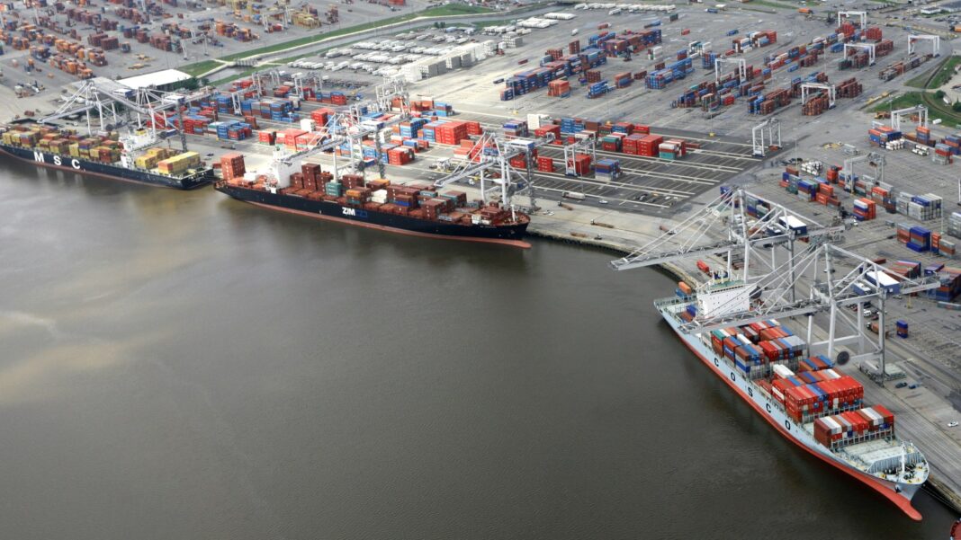 U.S. Current-Account Deficit Widens to $246 Billion; That Is Not a Jobs Figure Aerial view of container ships docked along a river beside a port terminal stacked with shipping containers