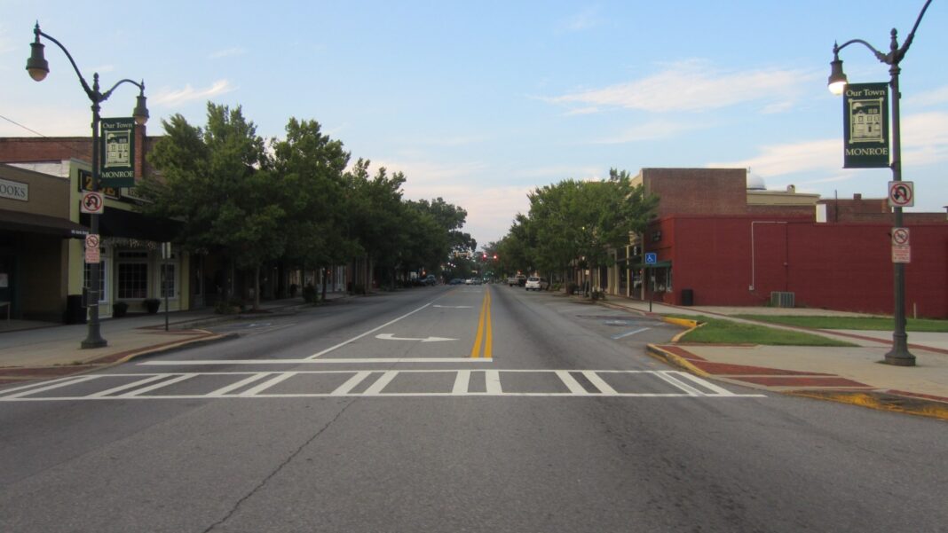 Walton County’s DeltaX Project Could Add 250 Jobs, but Monroe’s Hiring Timetable Is Still Ahead A wide, empty main street in downtown Monroe, Georgia, lined with brick buildings and street lamps