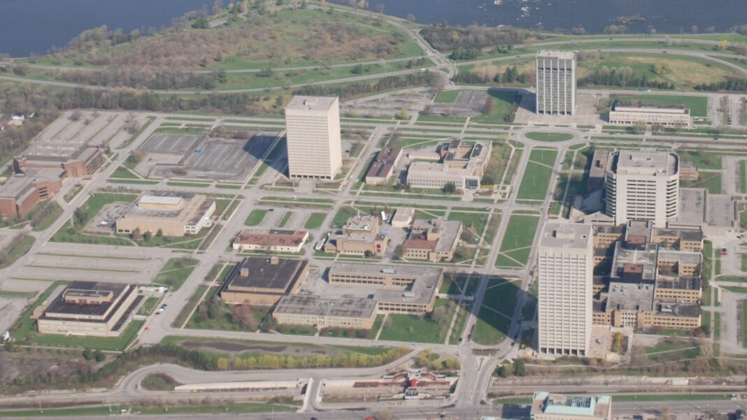 Aerial view of a campus of office towers and low government buildings separated by roads and parking lots