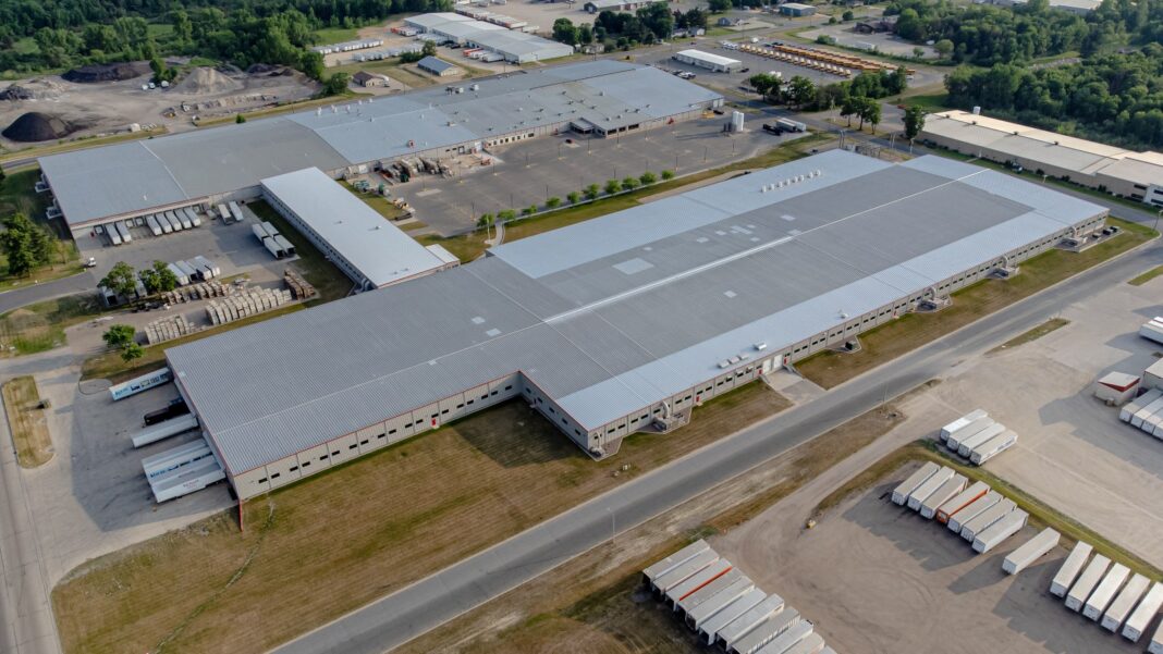 Cardinal Glass Files to Close Its Statesboro Plant, Affecting 115 Georgia Workers Aerial view of a large, low gray factory building with parking lots, truck trailers and green fields around it