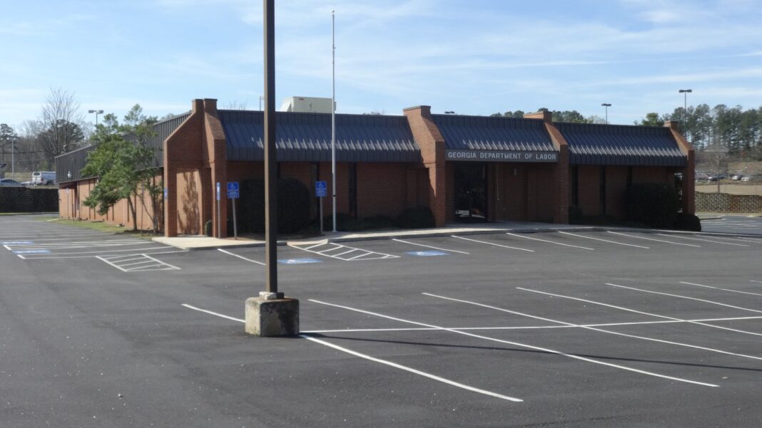 Georgia’s Labor Force Hits Another Record in September, but Payroll Jobs Slip and Unemployment Edges Up to 3.3% A single-story brick building with a dark metal roof and a sign reading Georgia Department of Labor, behind a mostly empty parking lot.
