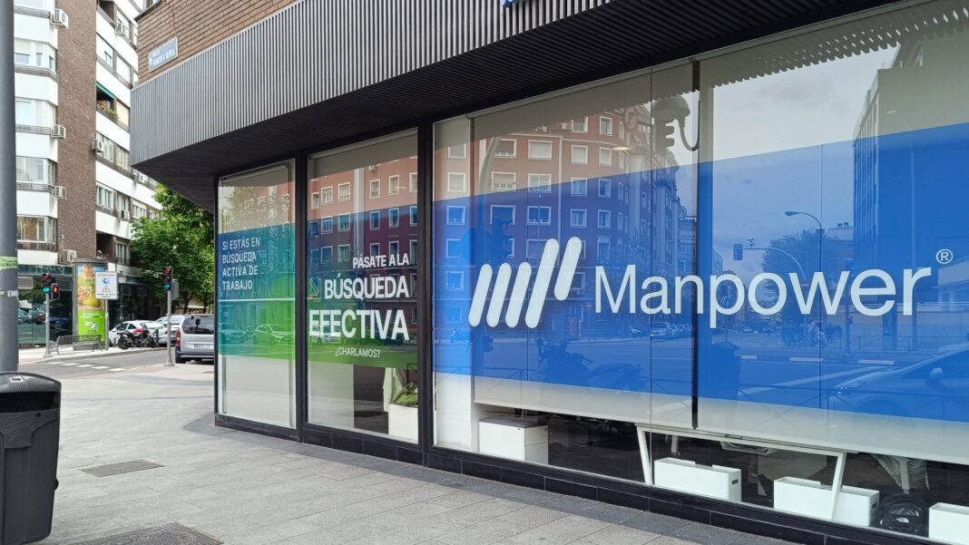 ManpowerGroup’s U.S. Revenue Rose 5.5% in the Third Quarter as Experis Returned to Growth A glass-fronted street-corner office with a large blue Manpower logo and Spanish-language job-search posters in the windows