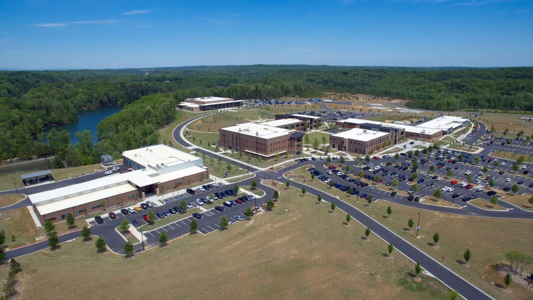 The Upside: Skilled Work Still Has a Place in Georgia’s Next Investment Cycle Aerial view of a college campus of low brick and white buildings, parking lots and a curving road, with a lake and wooded hills behind it.