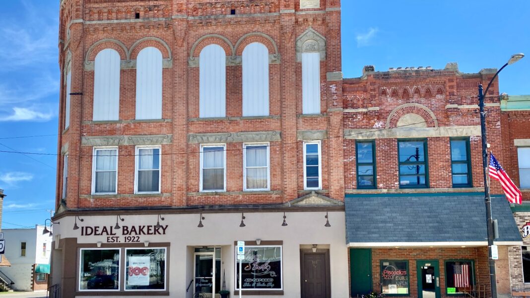 Three Small-Business Data Sets Are Sending Different Hiring Signals A three-story red-brick building with arched windows houses the Ideal Bakery on a small-town main street beside an American flag